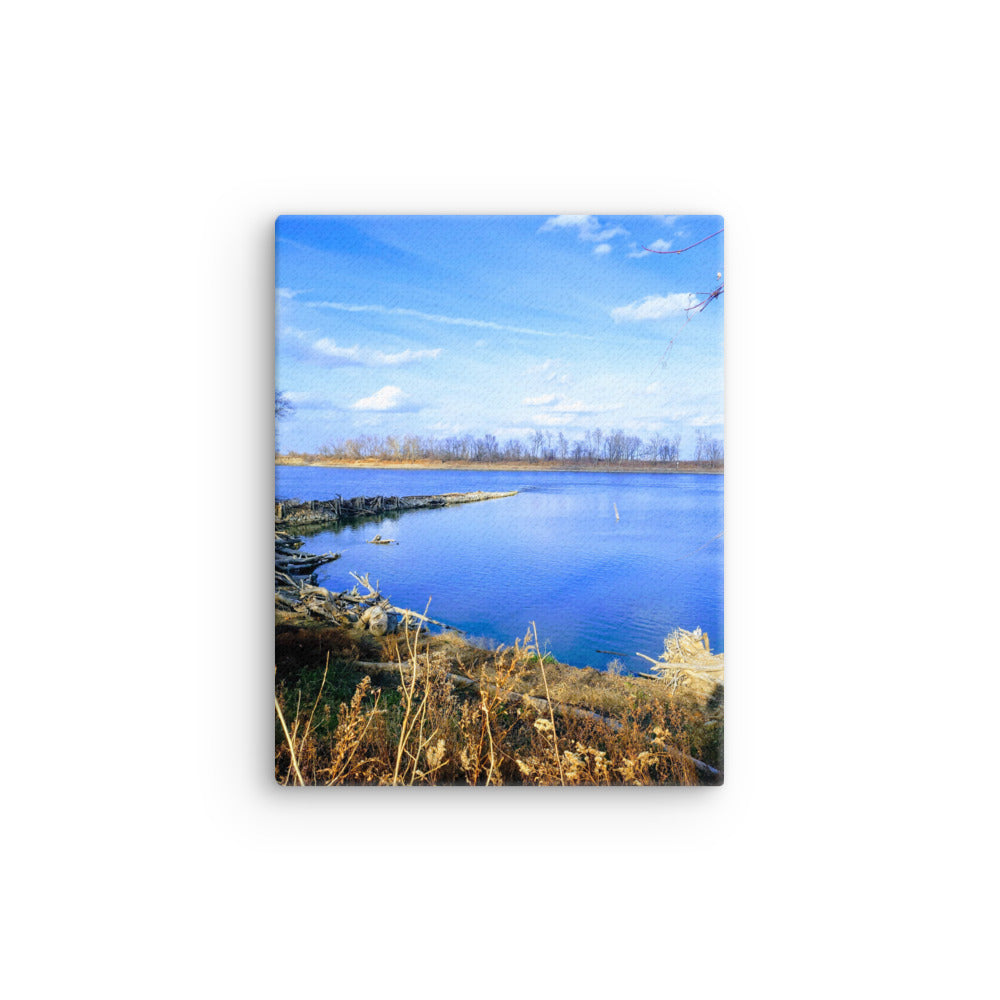 Bright blue river landscape scene with blue sky and brown winter grasses