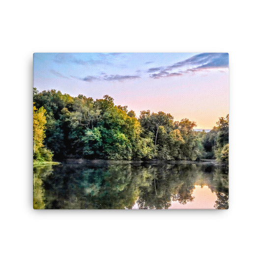 Lake surrounded by trees with a sunset reflection on the water