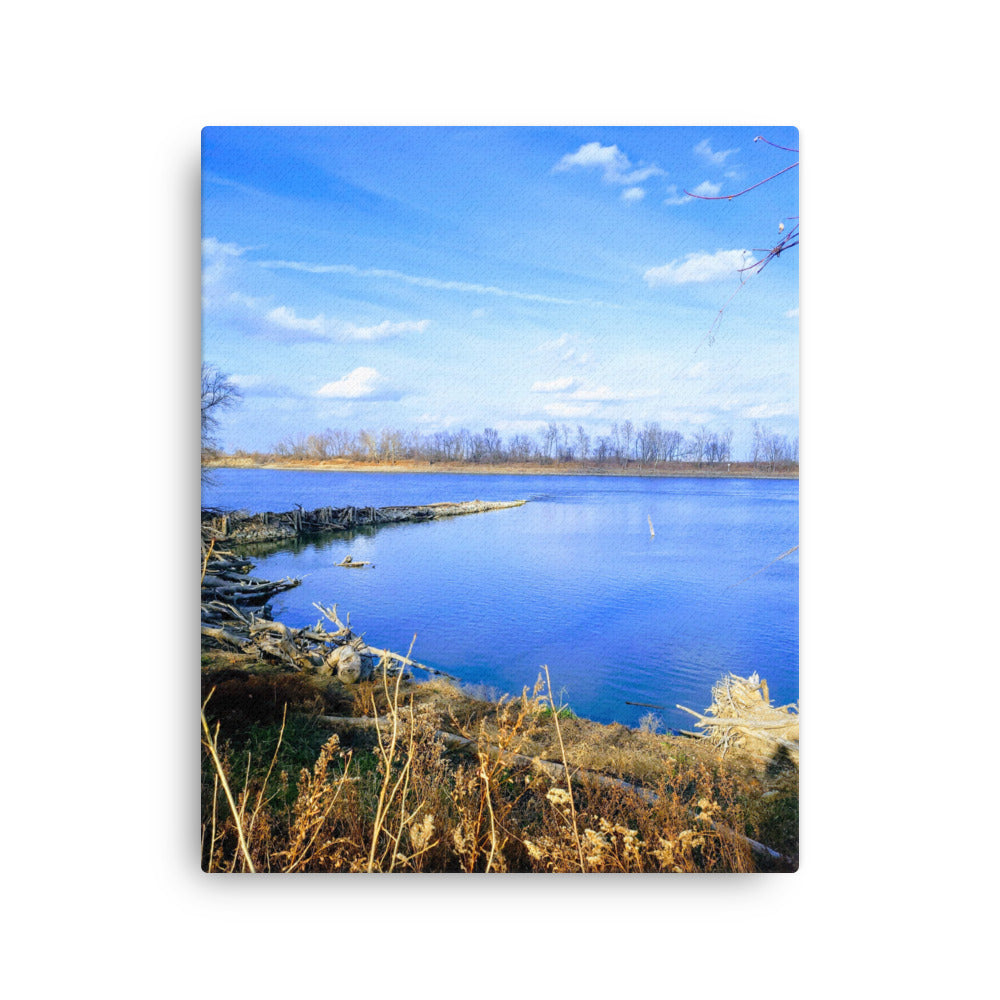 Bright blue river landscape scene with blue sky and brown winter grasses
