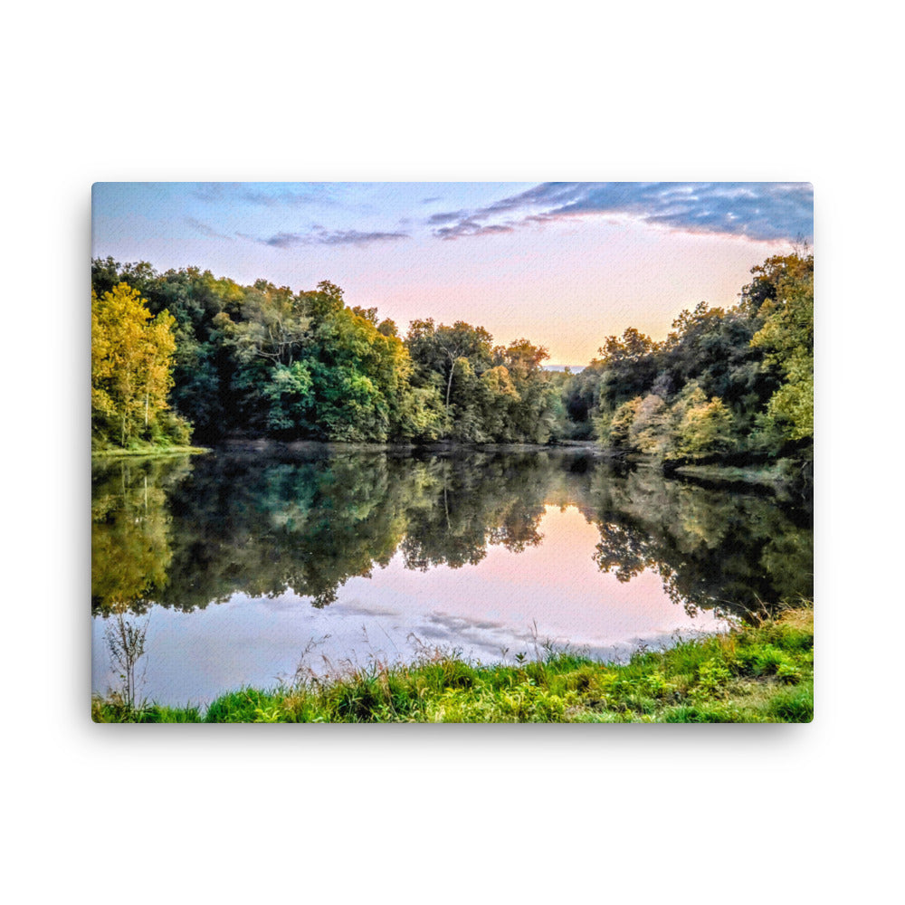 Lake surrounded by trees with a sunset reflection on the water