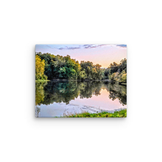Lake surrounded by trees with a sunset reflection on the water