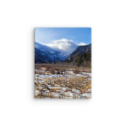 Mountain landscape with snow-covered peaks and a clear blue sky.